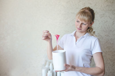 Portrait of young woman using mobile phone at home