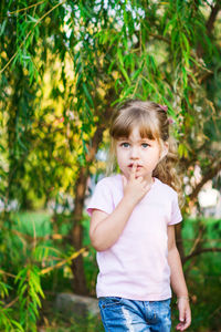 Portrait of cute girl standing against plants