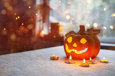 Halloween pumpkin lamp with candles fire in table at home. symbol of halloween, indoor decorations