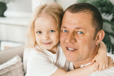 A little girl 4 years old gently hugs her dad.