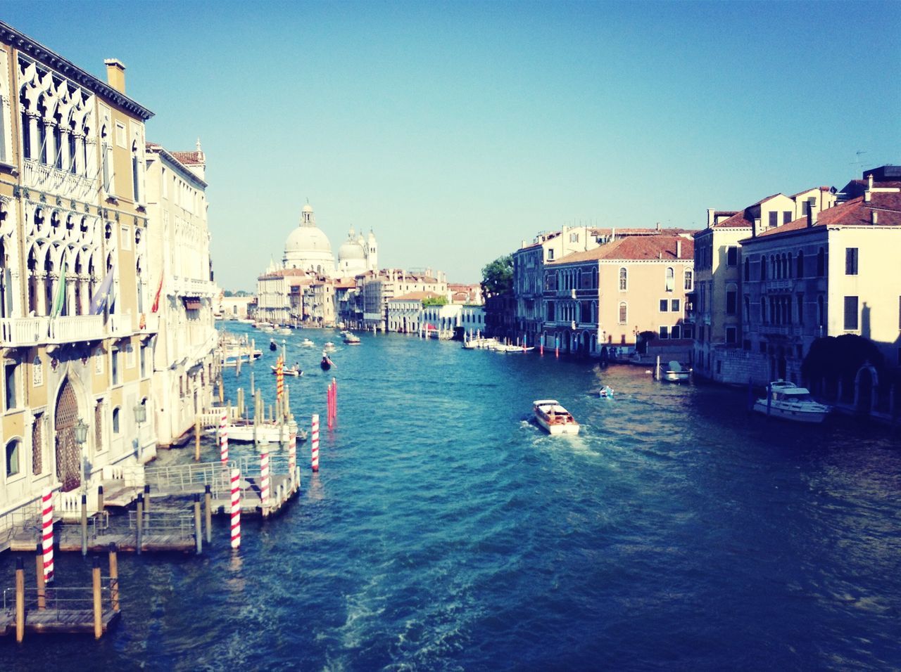 building exterior, architecture, built structure, water, nautical vessel, clear sky, transportation, waterfront, boat, mode of transport, canal, church, copy space, travel, moored, city, residential structure, blue, religion, residential building