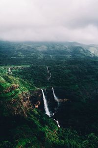 Scenic view of waterfall against sky