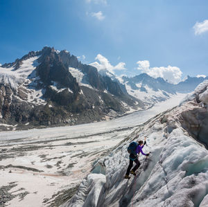 Person on snowcapped mountain against sky