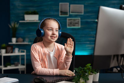 Cute girl talking on video conference at home