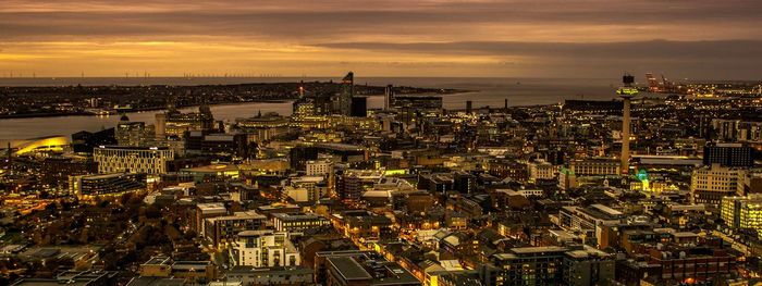 High angle view of city against cloudy sky during sunset