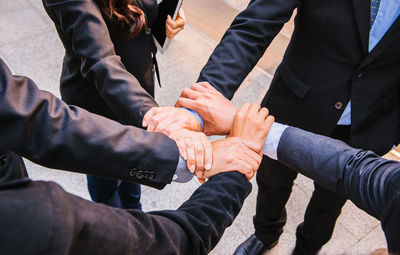 High angle view of business people forming hand chain