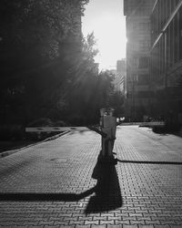 Shadow of person on footpath by street