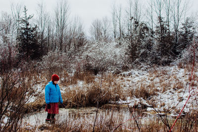 Girl standing at forest during winter