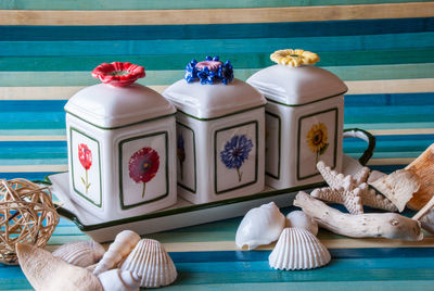Close-up of ceramic containers with seashells on table