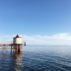 Pier over sea against blue sky