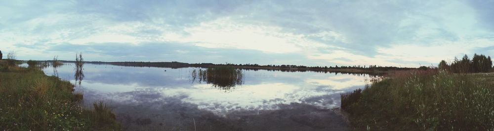 Scenic view of lake against cloudy sky