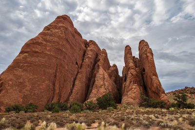 Rock formations in desert against cloudy sky