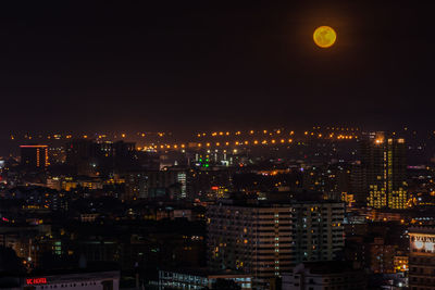 Illuminated buildings in city against sky at night