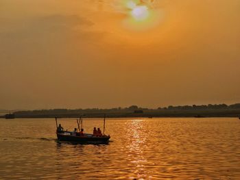 Silhouette boat sailing on sea against sky during sunset