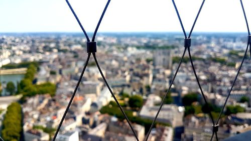 Close-up of metal chain against buildings in city