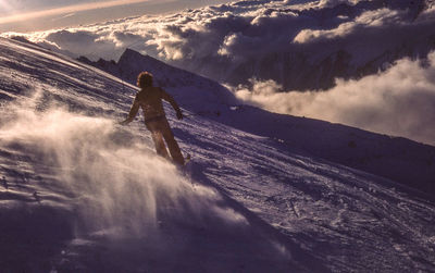 Rear view of man skiing on ski slope