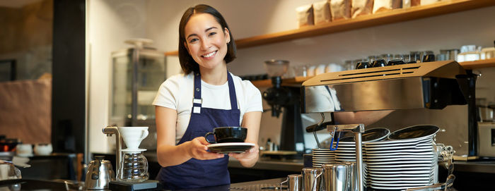 Portrait of young woman using mobile phone at home