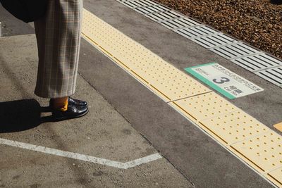 Low section of person standing on road