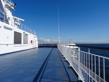 Pier amidst sea against clear blue sky