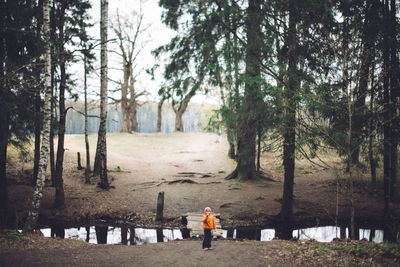 Kid standing on overpass in forest