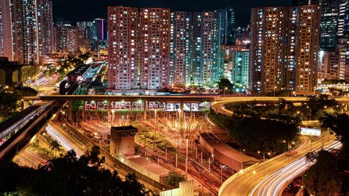 High angle view of illuminated city street and buildings at night