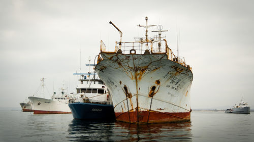 Ship moored at harbor against sky