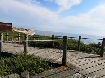 Footpath by sea against sky