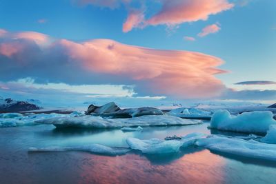 Scenic view of frozen lake against sky during sunset