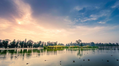 Scenic view of lake against sky at sunset