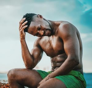 Portrait of shirtless young man in swimming pool