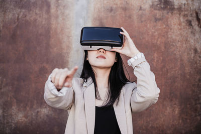 Chinese businesswoman using virtual reality headset in city. technology