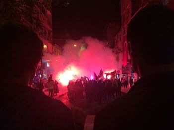 Rear view of people enjoying music concert at night