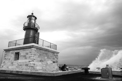 Lighthouse by sea against sky