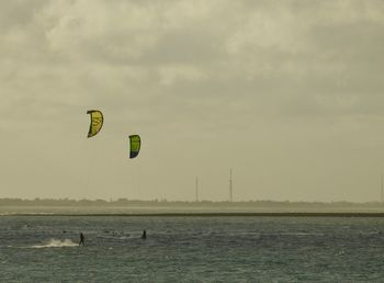 Scenic view of sea against sky with kite surfers 