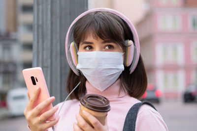 Portrait of woman holding smart phone in city