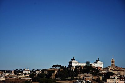 View of cityscape against clear blue sky