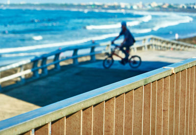 Man riding bicycle on railing