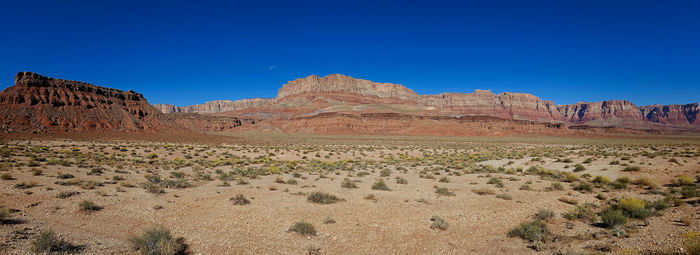 Scenic view of desert against clear blue sky