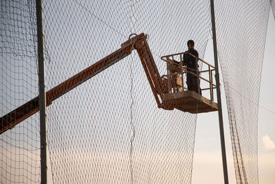 Low angle view of man working at construction site