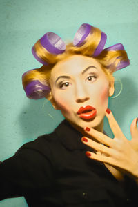 Portrait of young woman against colored background