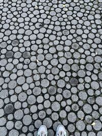 Low section of person standing on cobblestone street