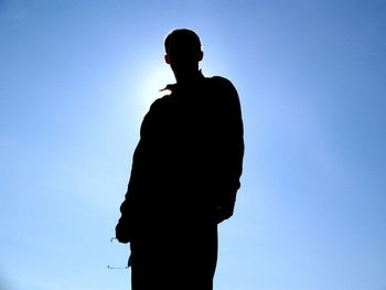 Low angle view of silhouette people against clear blue sky