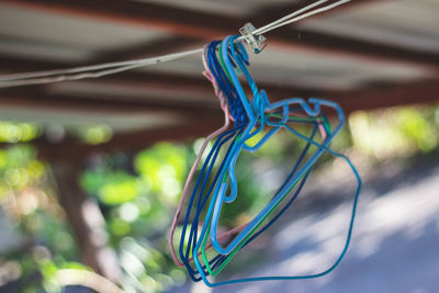 Close-up of colorful coathangers hanging on clothesline