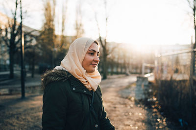 Young muslim woman wearing hijab in city during sunset