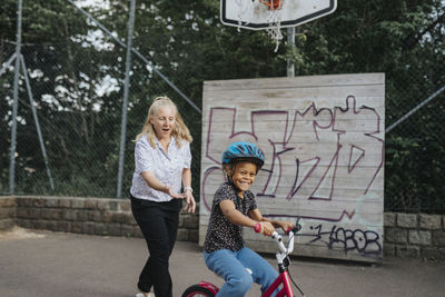 Mother teaching daughter to ride bike