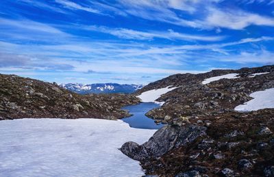 Scenic view of snowcapped mountains against blue sky