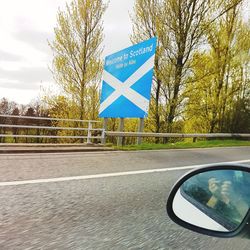 Close-up of road sign against sky