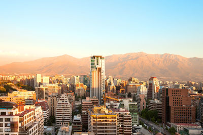 High angle view of cityscape and mountain against blue sky