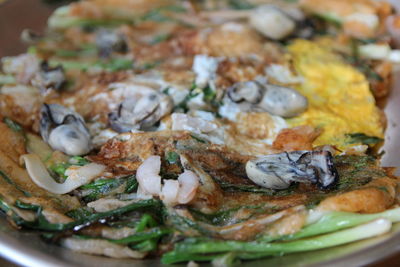 Focus on oyster on the korean pancake with the leek and egg at korean restaurant, busan, south korea