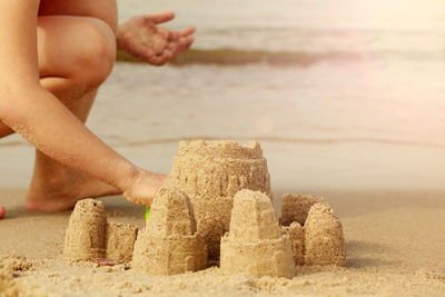 Midsection of person hand on sand at beach